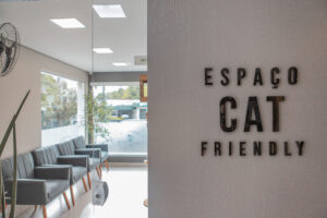 Sala de Espera para Felinos na LeVet. A imagem mostra a entrada da sala, com uma placa onde se lê "Espaço Cat Friendly" e um ambiente iluminado, contendo cadeiras e ventilador.
